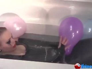 Látex vestido jovem senhora com balões em um banheira